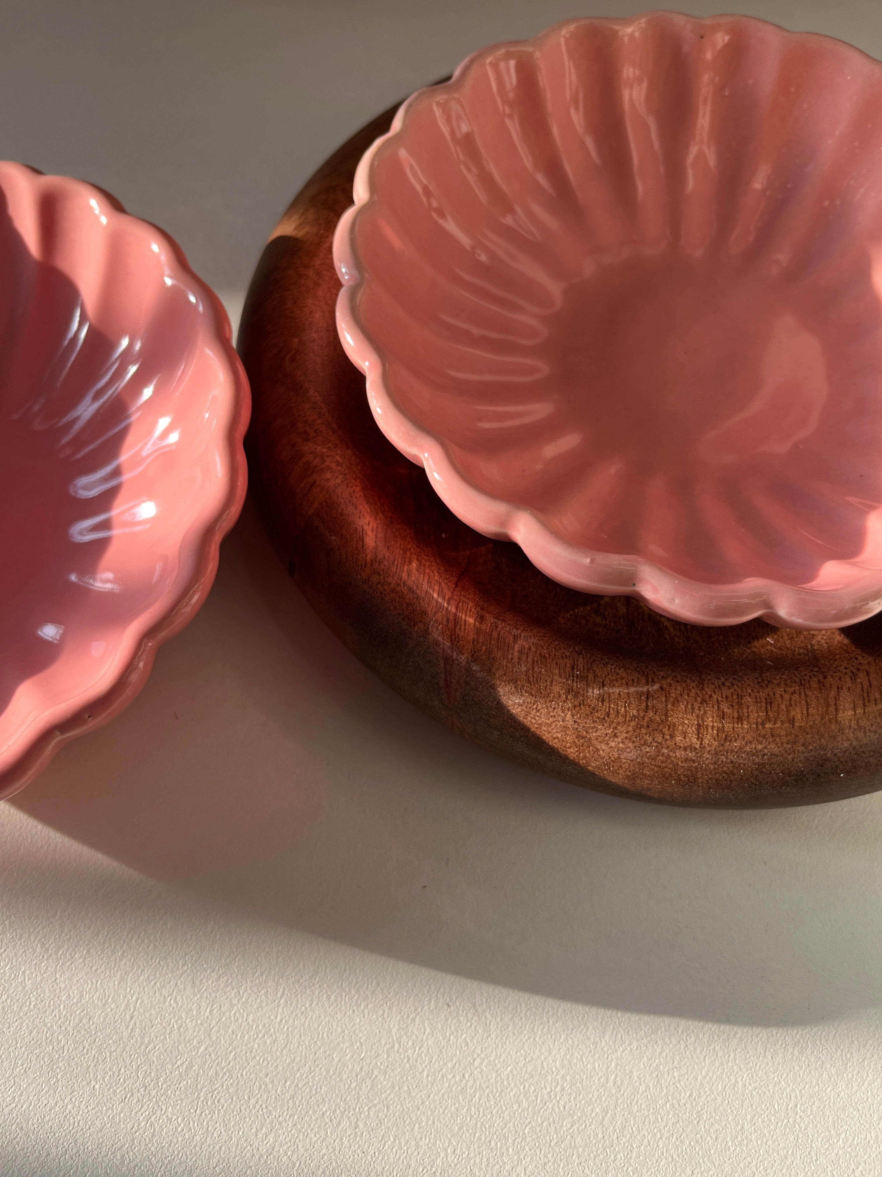 Pink flower-like dessert bowl in a wooden tray on a light gray background