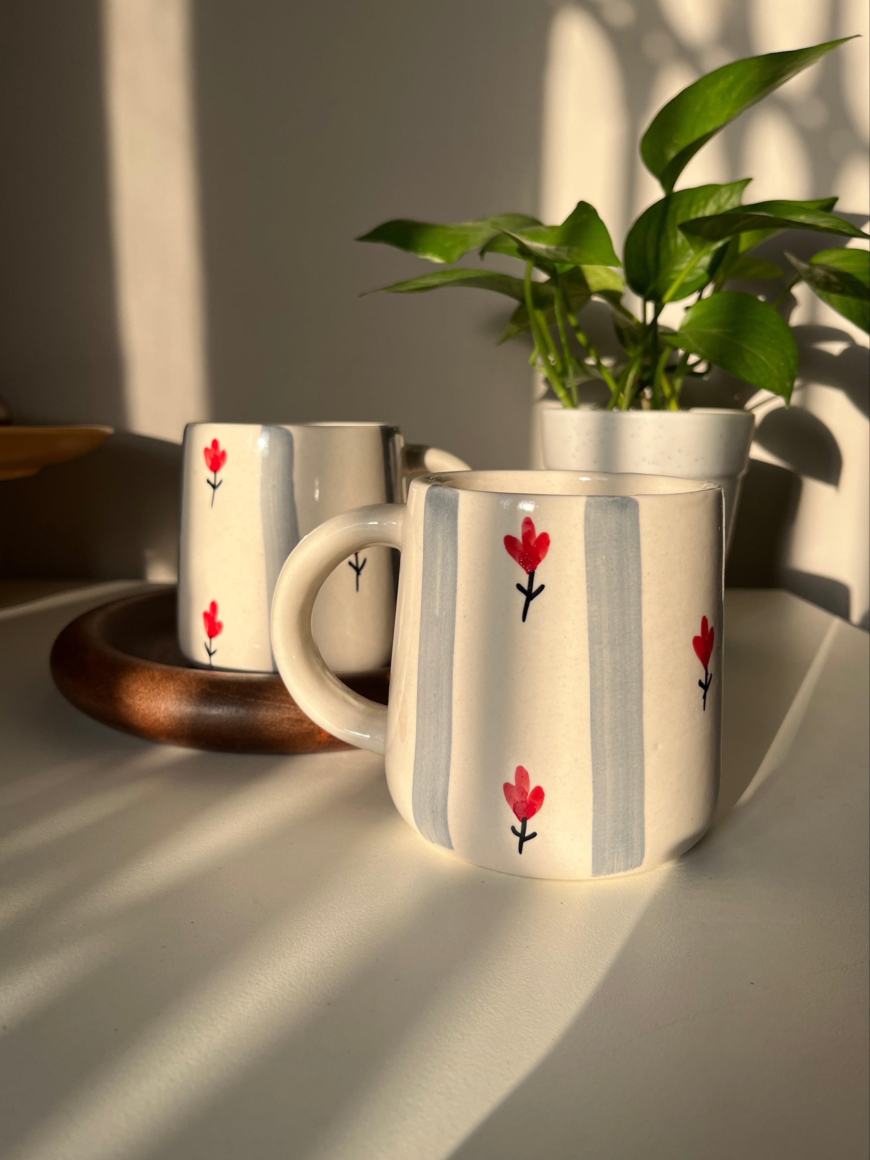 Grey striped ceramic mug with cream/white base, pretty red floral motif