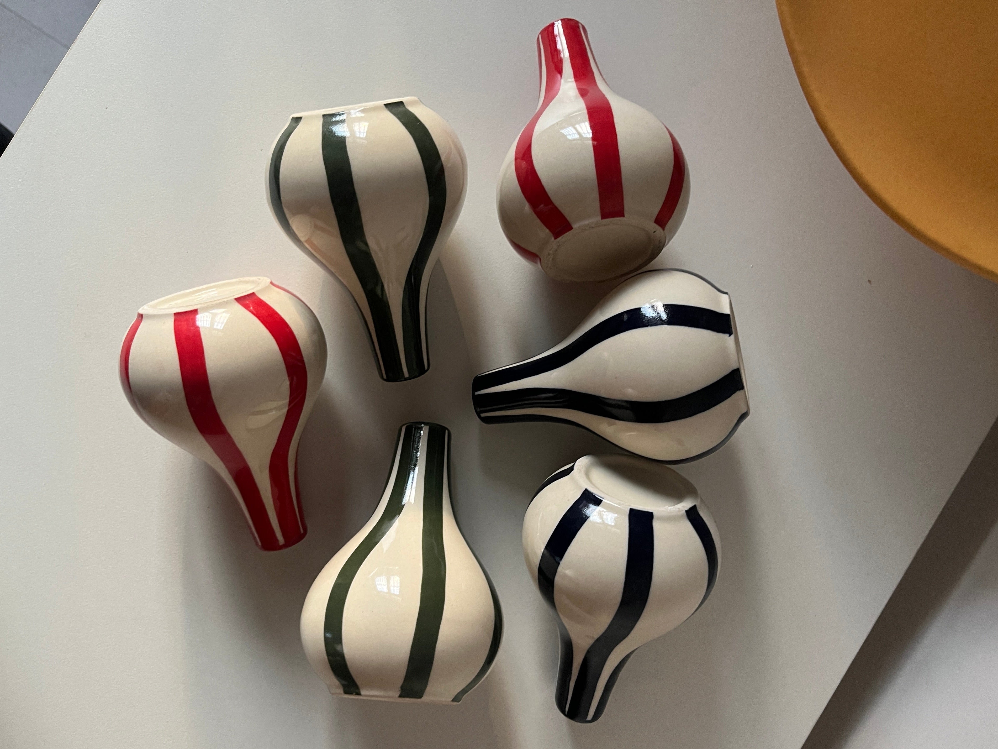 Set of five decorative vases with Blue, green and red stripes on a light gray background