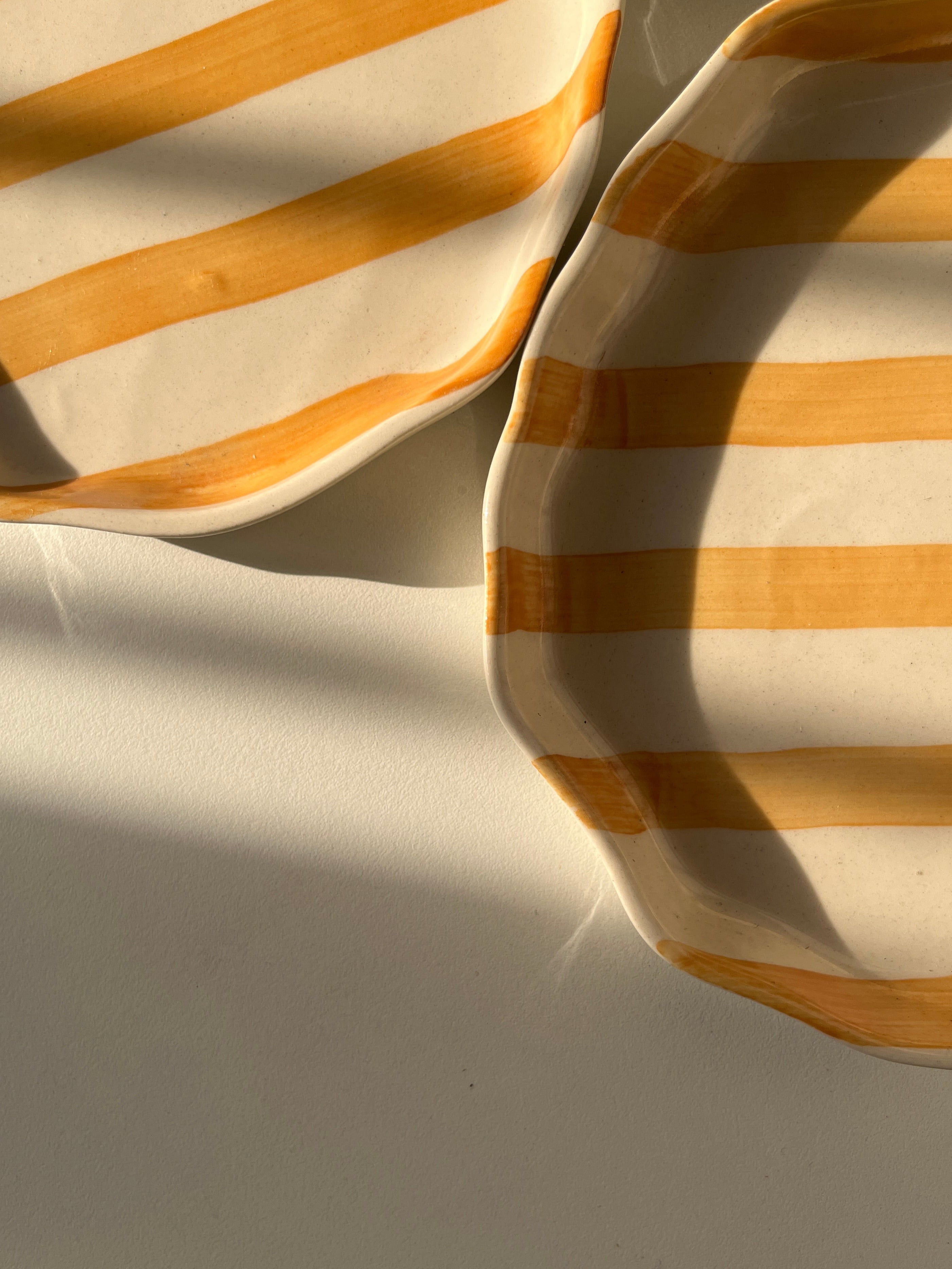 Close-up of striped ceramic plate with yellow and off-white colors