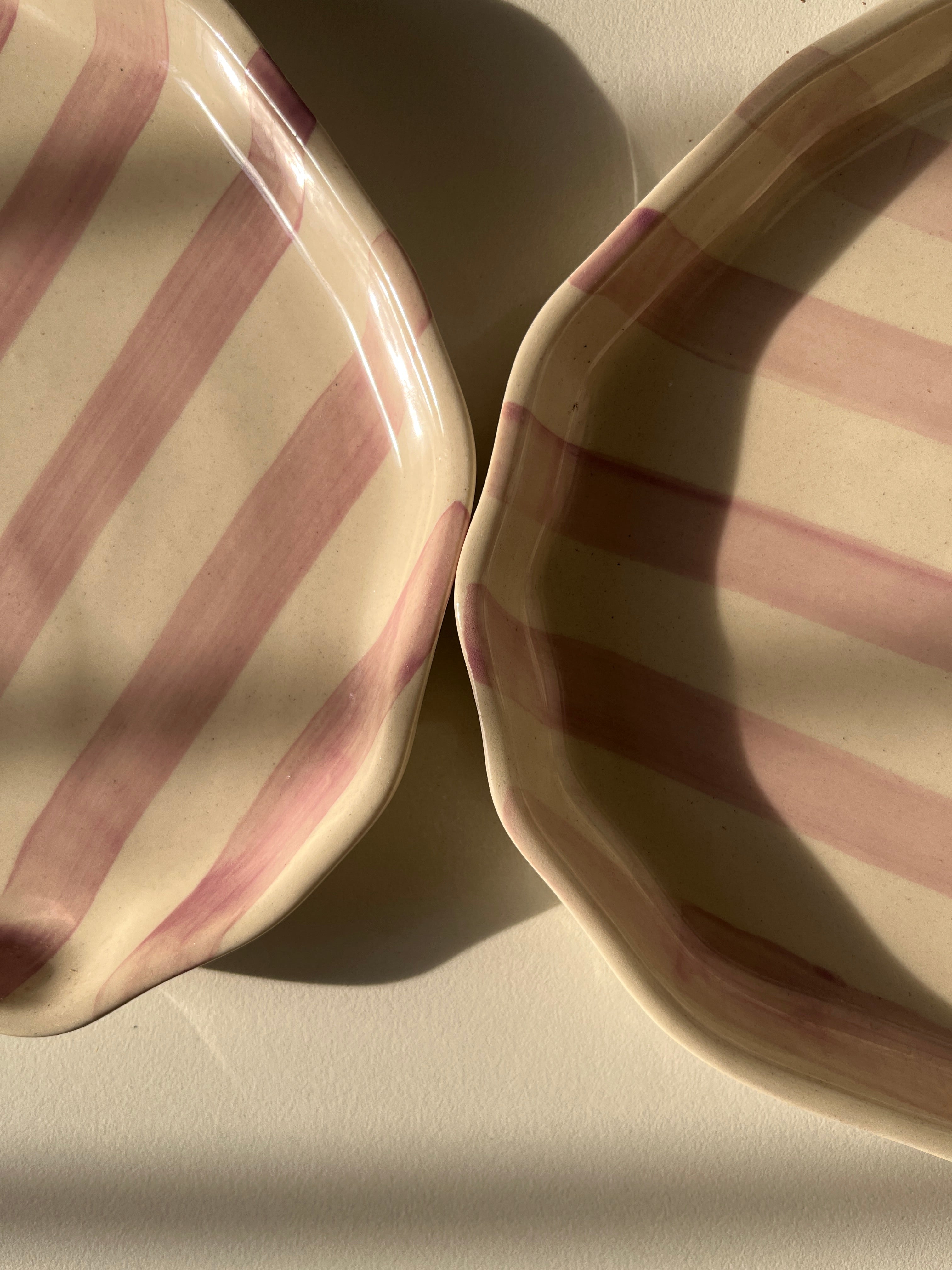 Two striped ceramic plates on a light background
