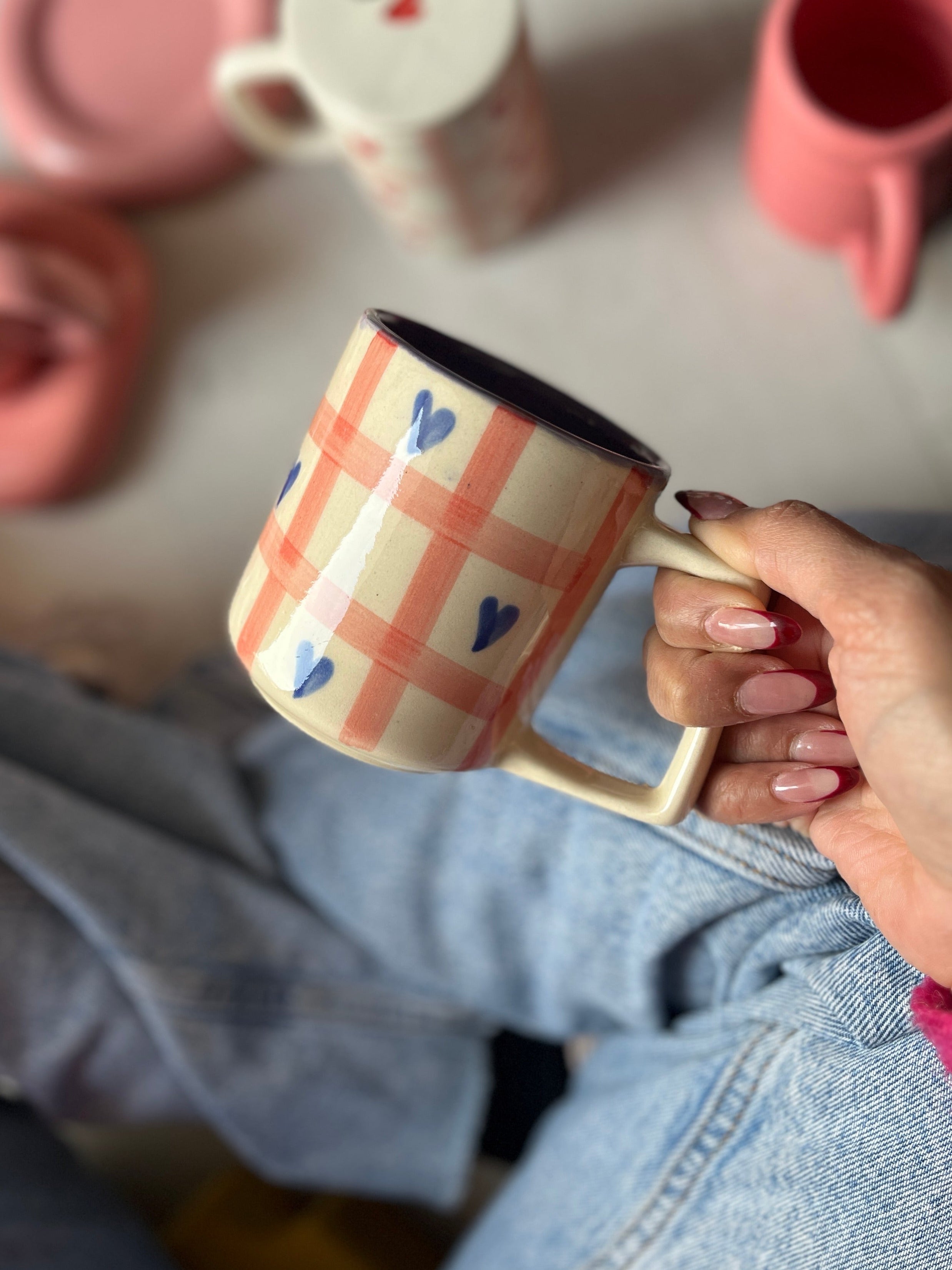 Purple heart and pink check on a ceramic mug, purple paint in the center.