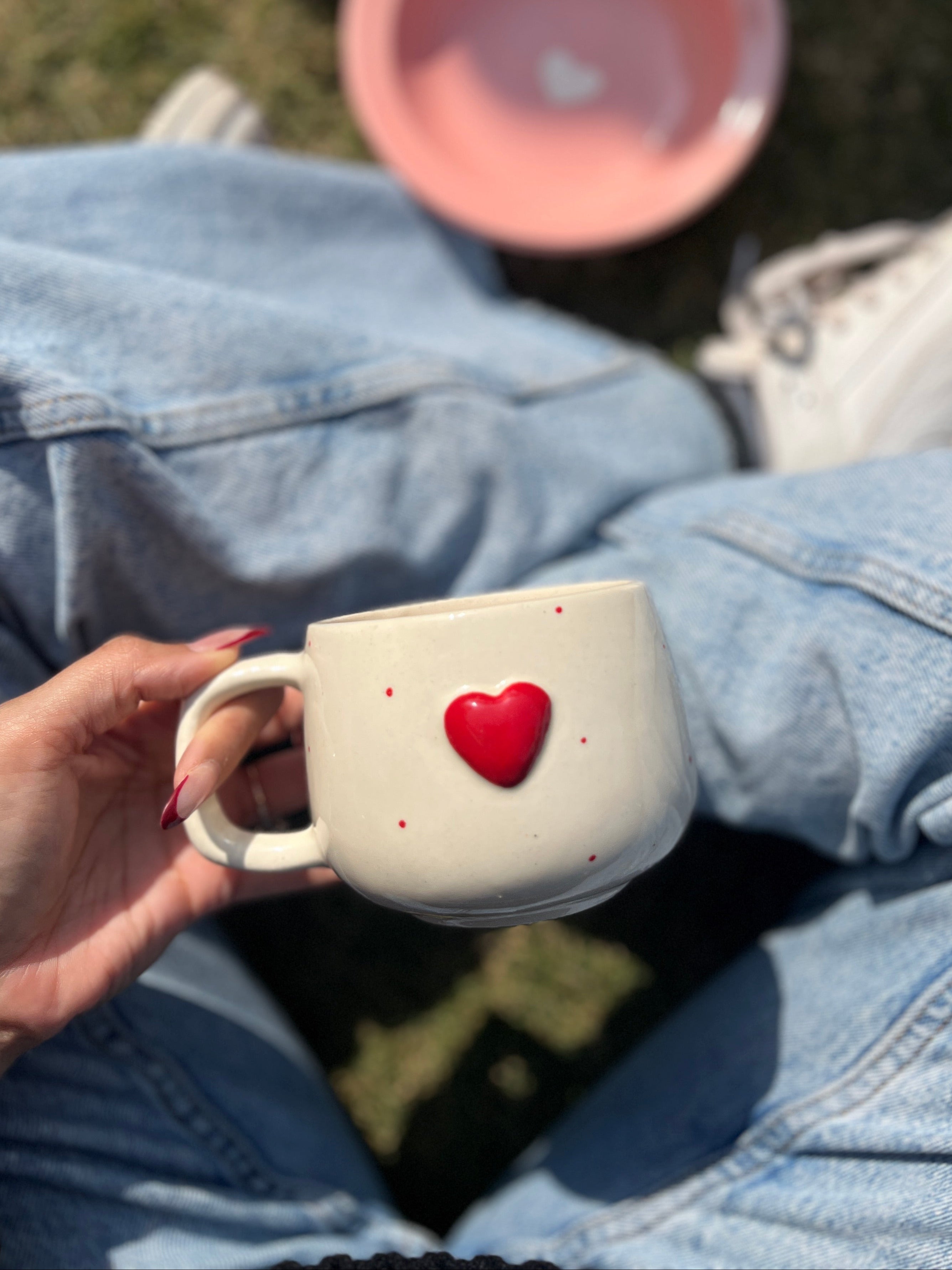 Person holding a small white container with a red heart on top, wearing a denim jacket. The heart is 3D and beautifully handcrafted.
