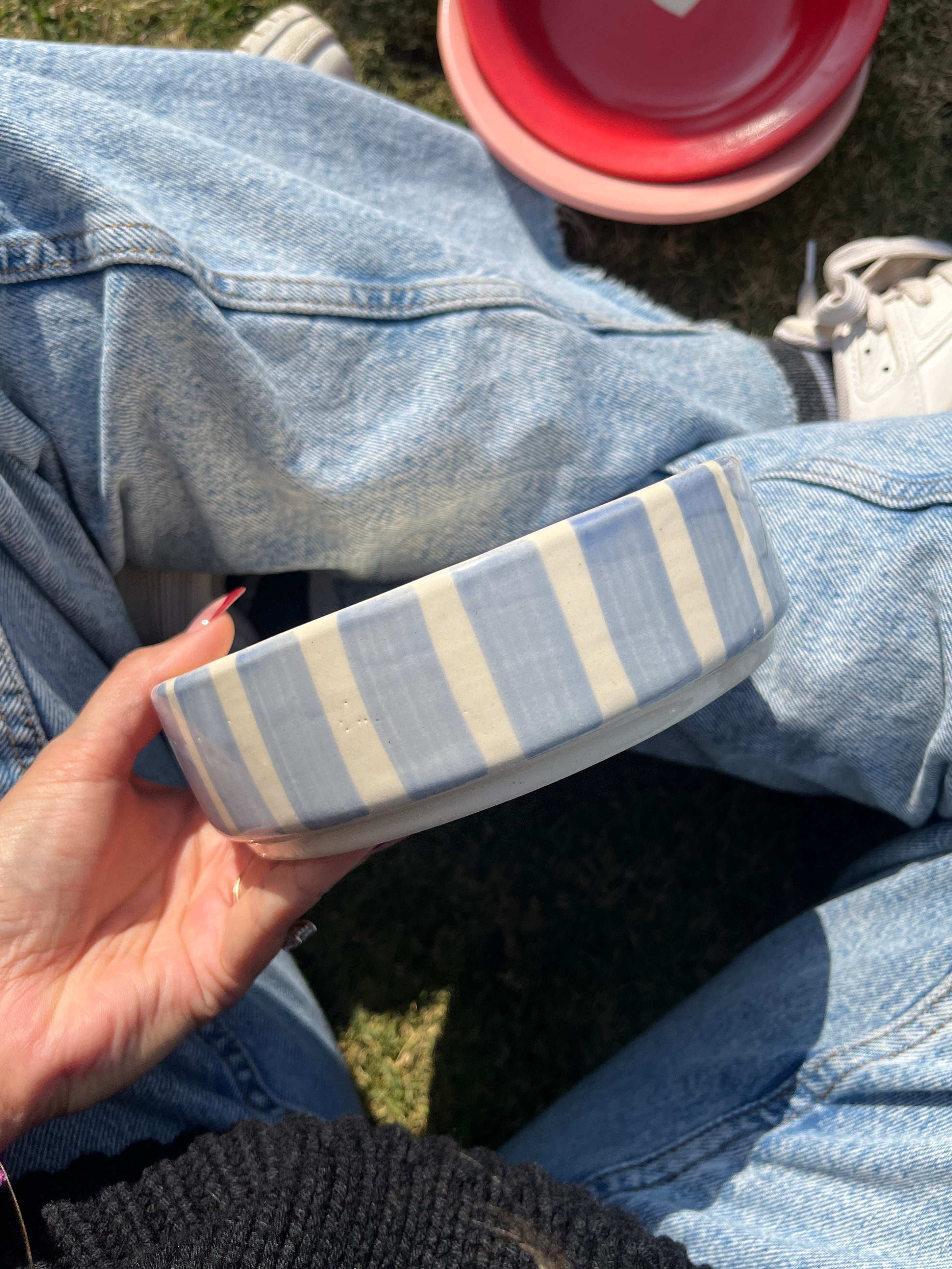 Person holding a striped blue and white bowl, elegant and modern cute aesthetic