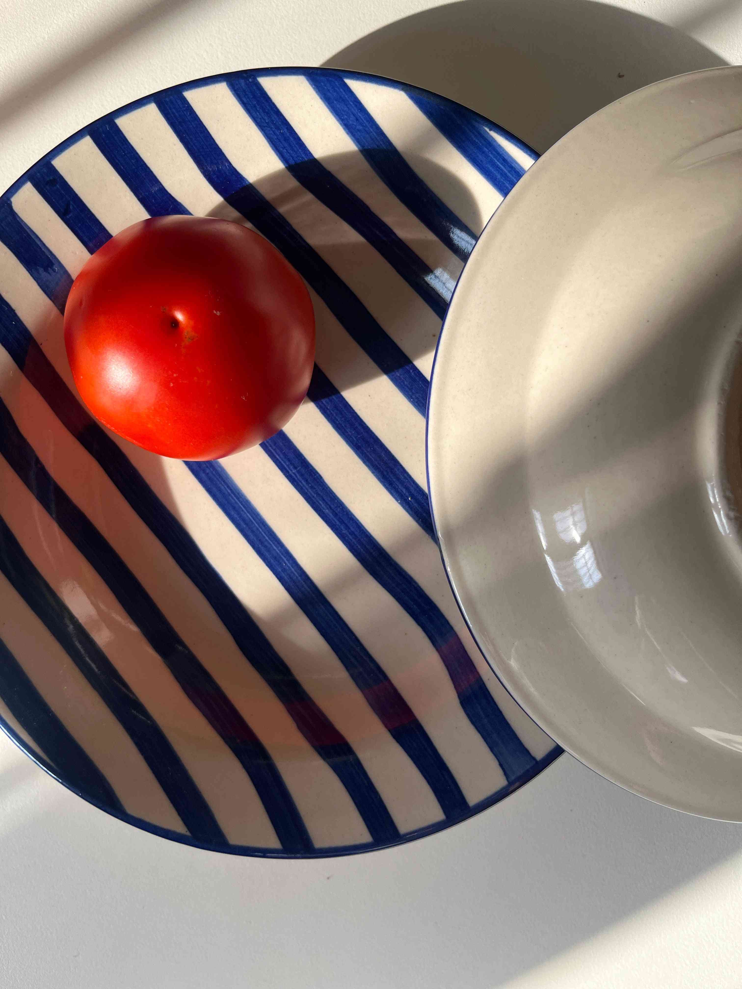 Hand-painted blue stripe pasta plate on cream ceramic base front and back