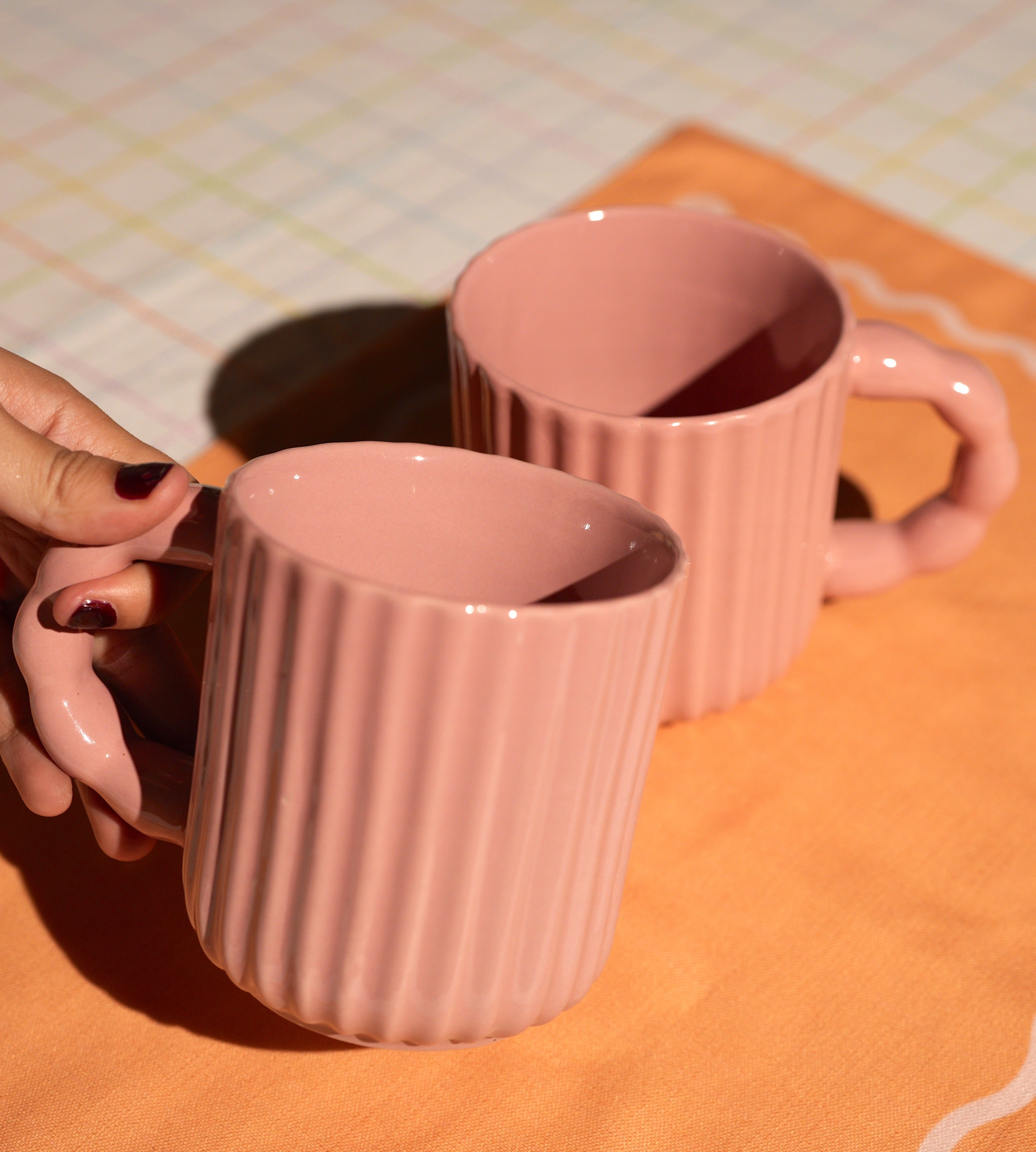 Two handcrafted ceramic mugs with textured fluted design