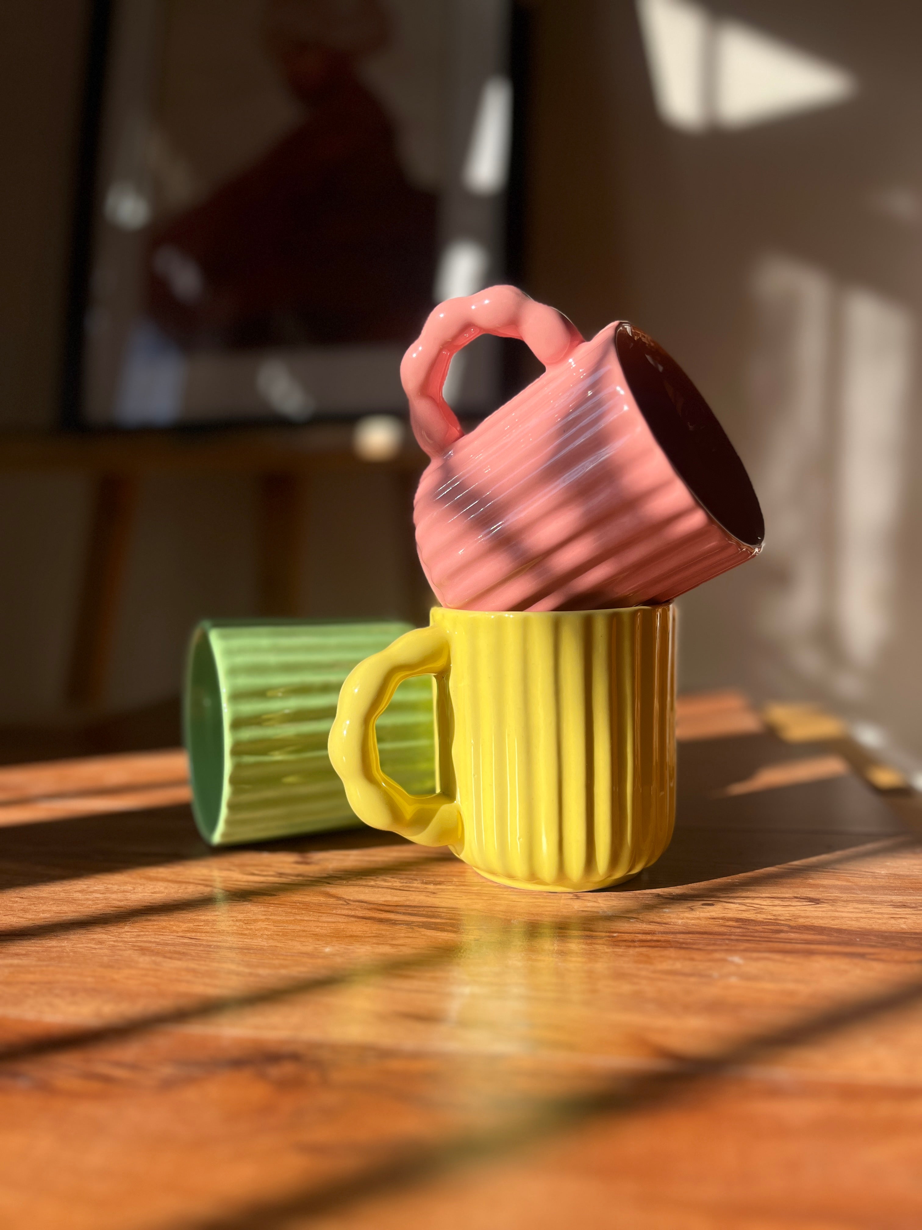 Front view of the Chonky Sips set with pink, yellow, and green ceramic mugs.