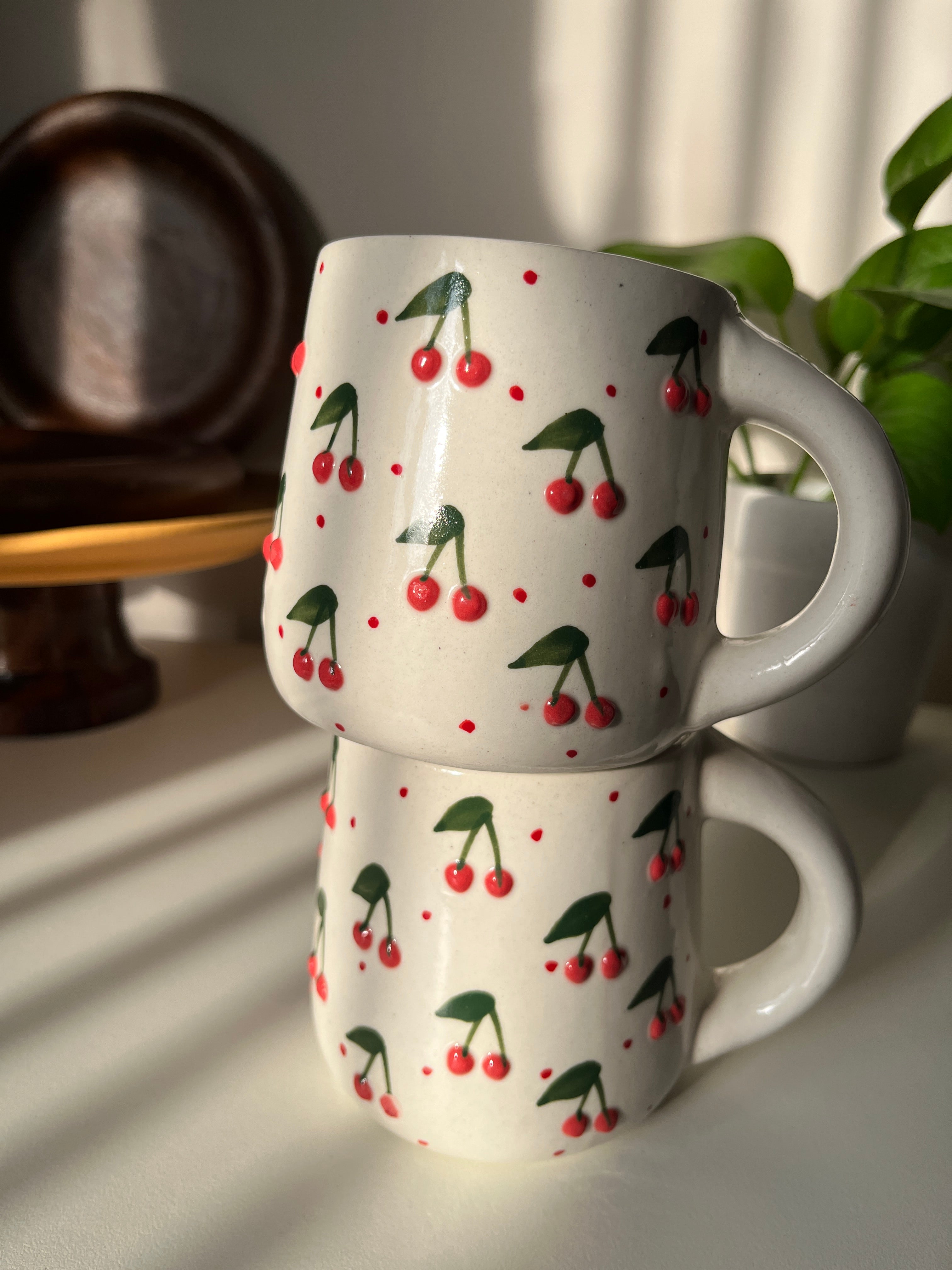 Close-up of 3D cherry embellishments on ceramic mug