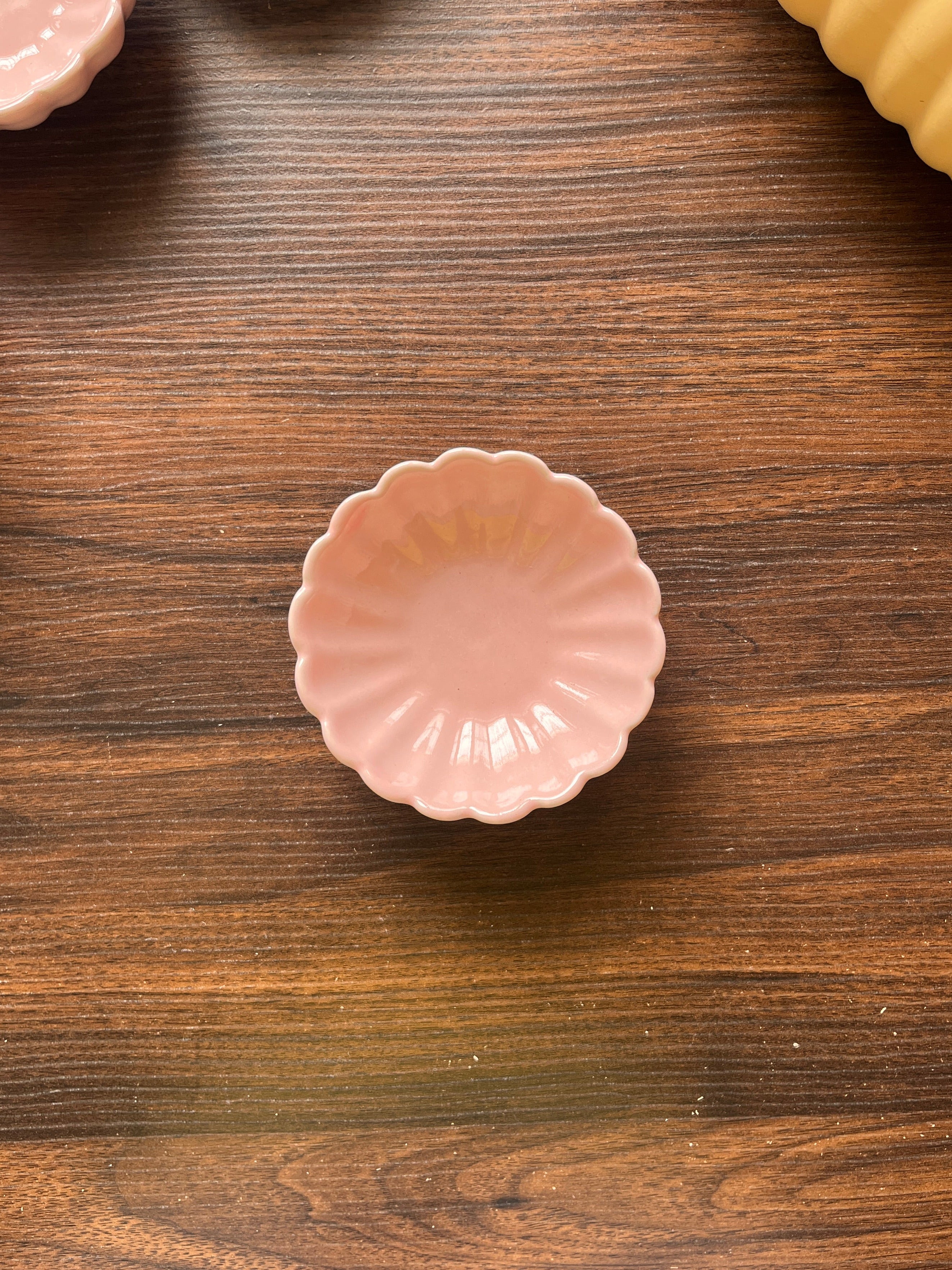 Top view of a pink flowery ceramic bowl on a wooden surface