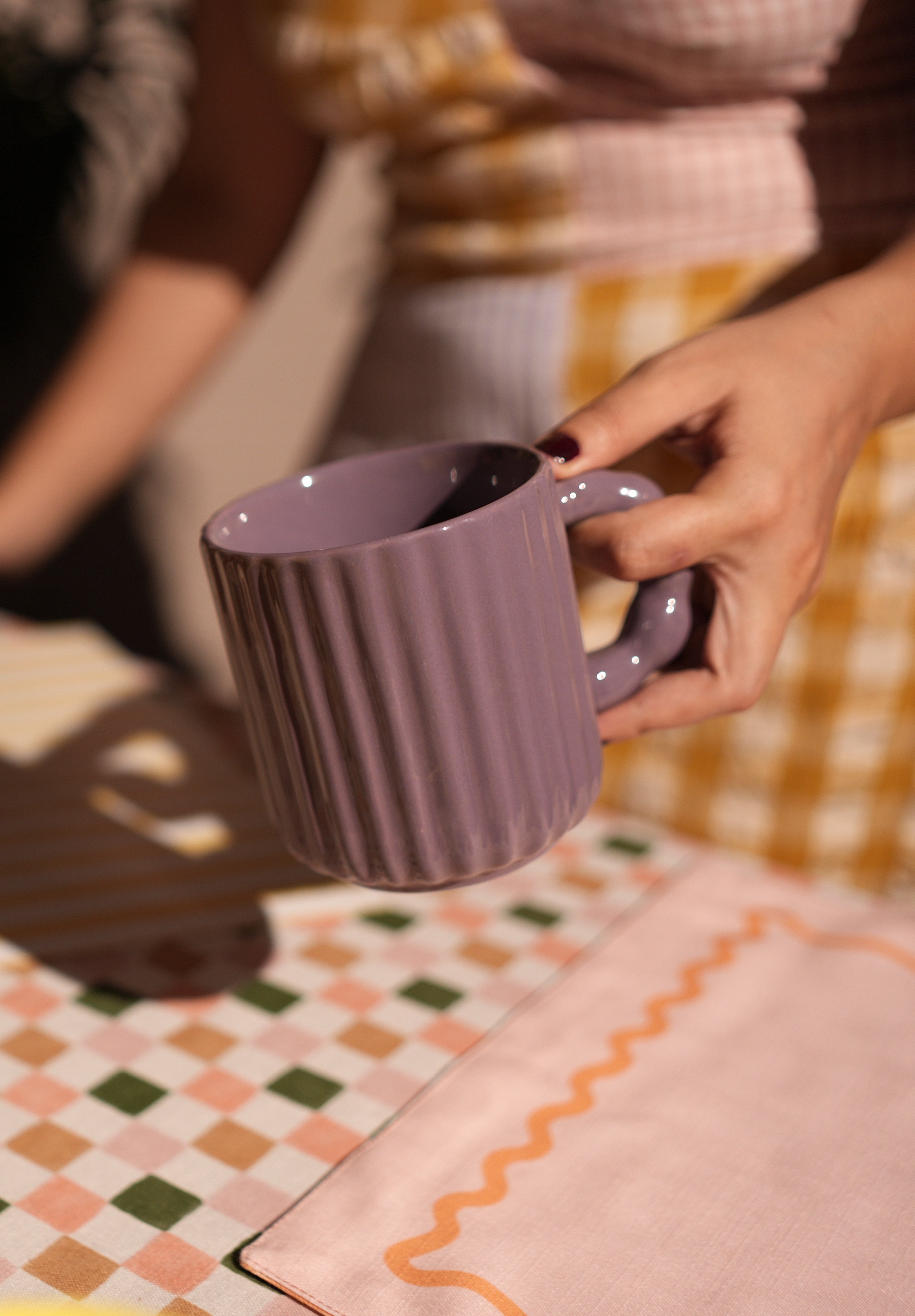 Person holding a modern ceramic coffee mug with ergonomic handle