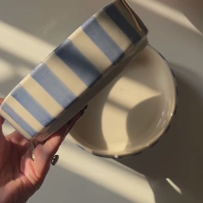 closeup of caprice blue stripe bowl in hand with sunlight 