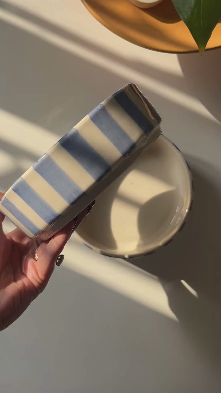 closeup of caprice blue stripe bowl in hand with sunlight 