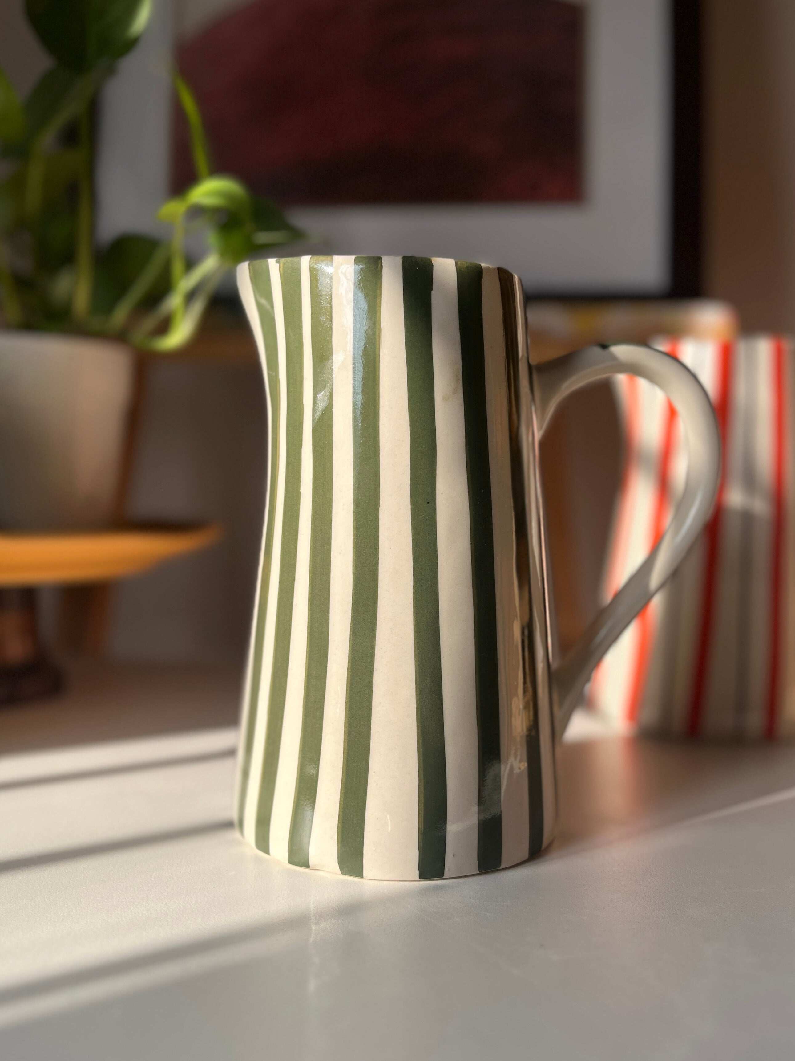 Glossy green striped ceramic vase for flowers and foliage