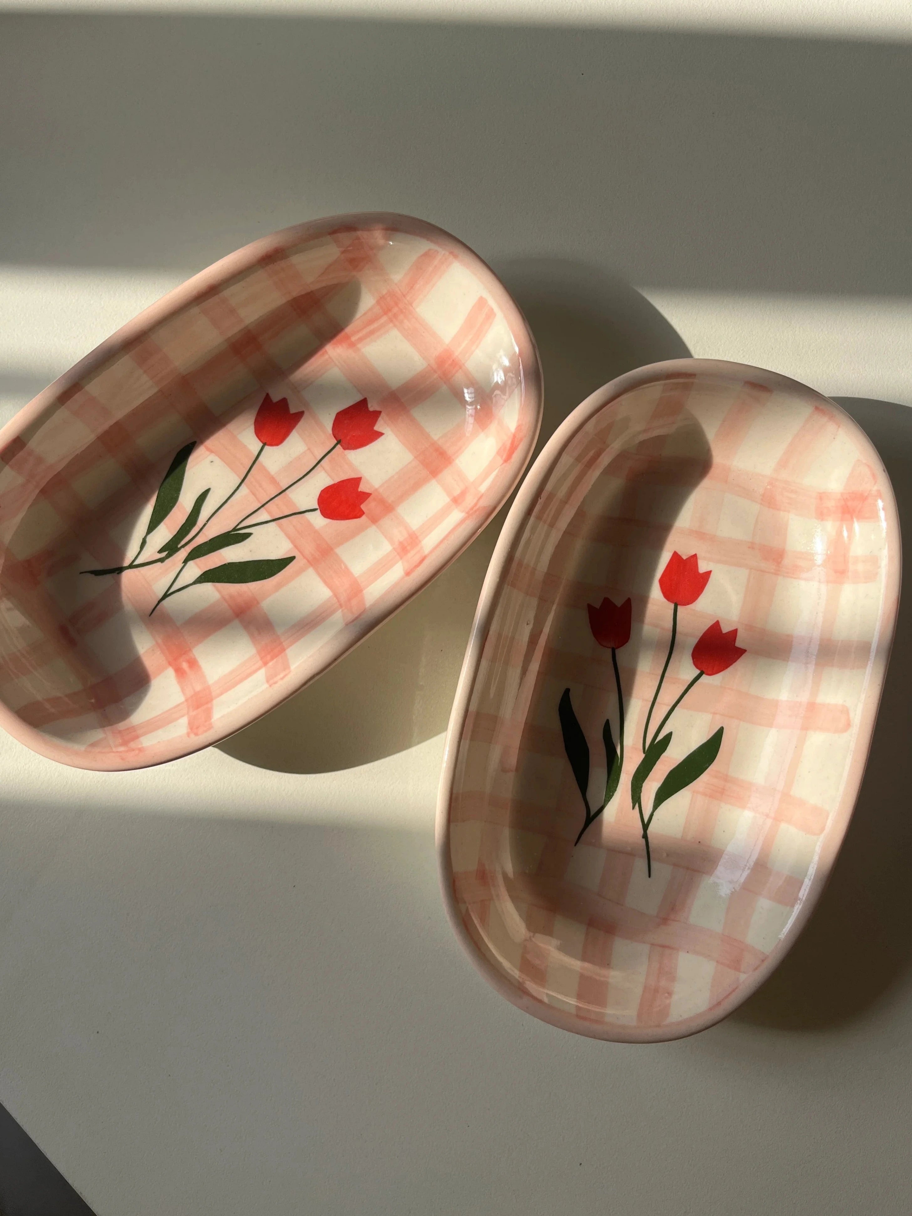 Top shot of Pink checkered ceramic tray with red tulip motifs